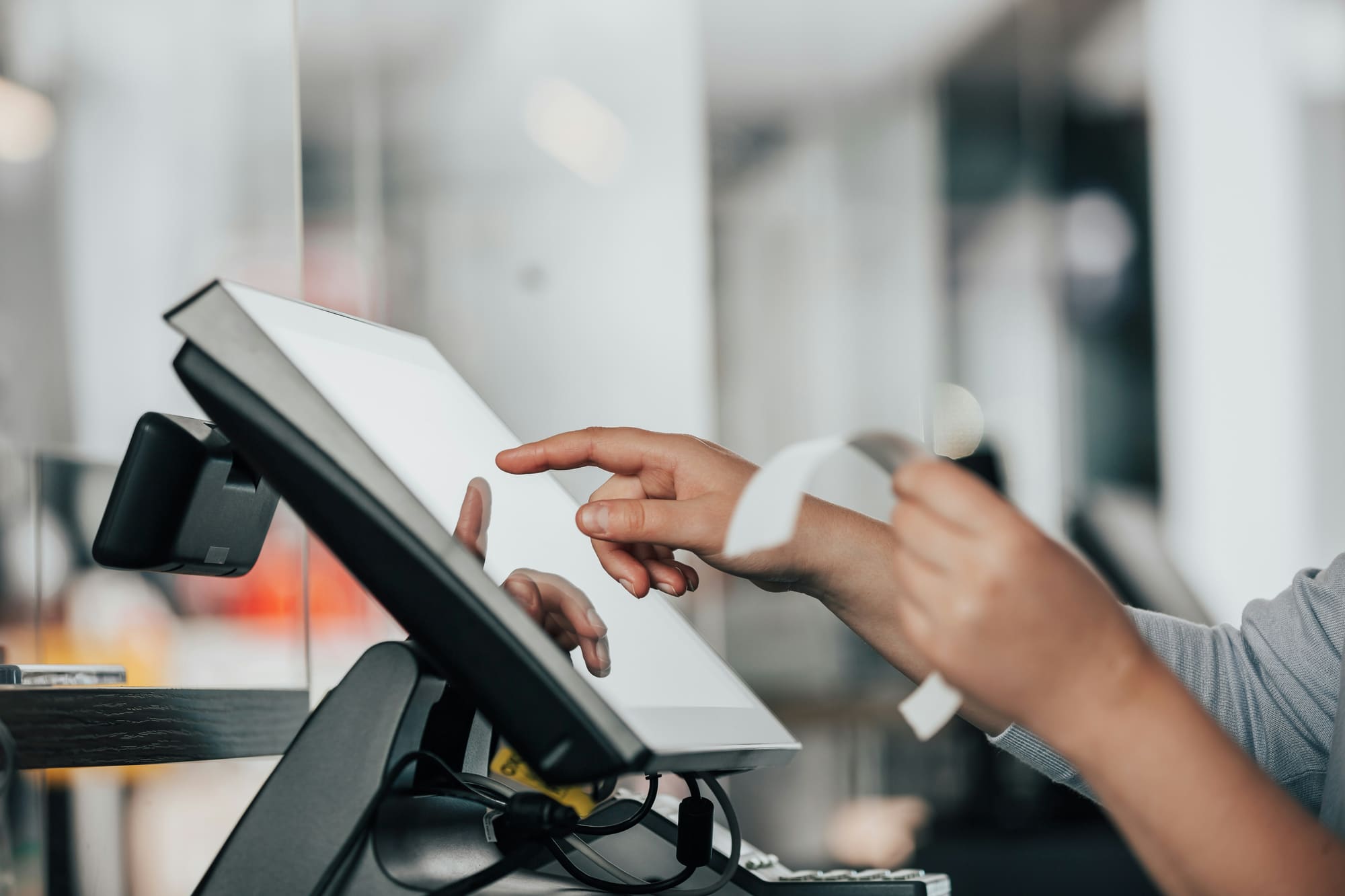 Staff member using the OneScale POS touchscreen terminal at checkout